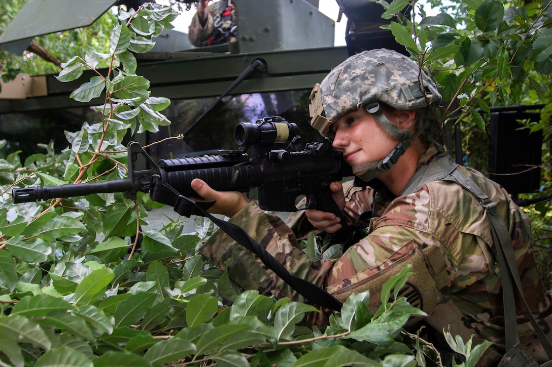 A soldier takes aim while providing security during a base security exercise.