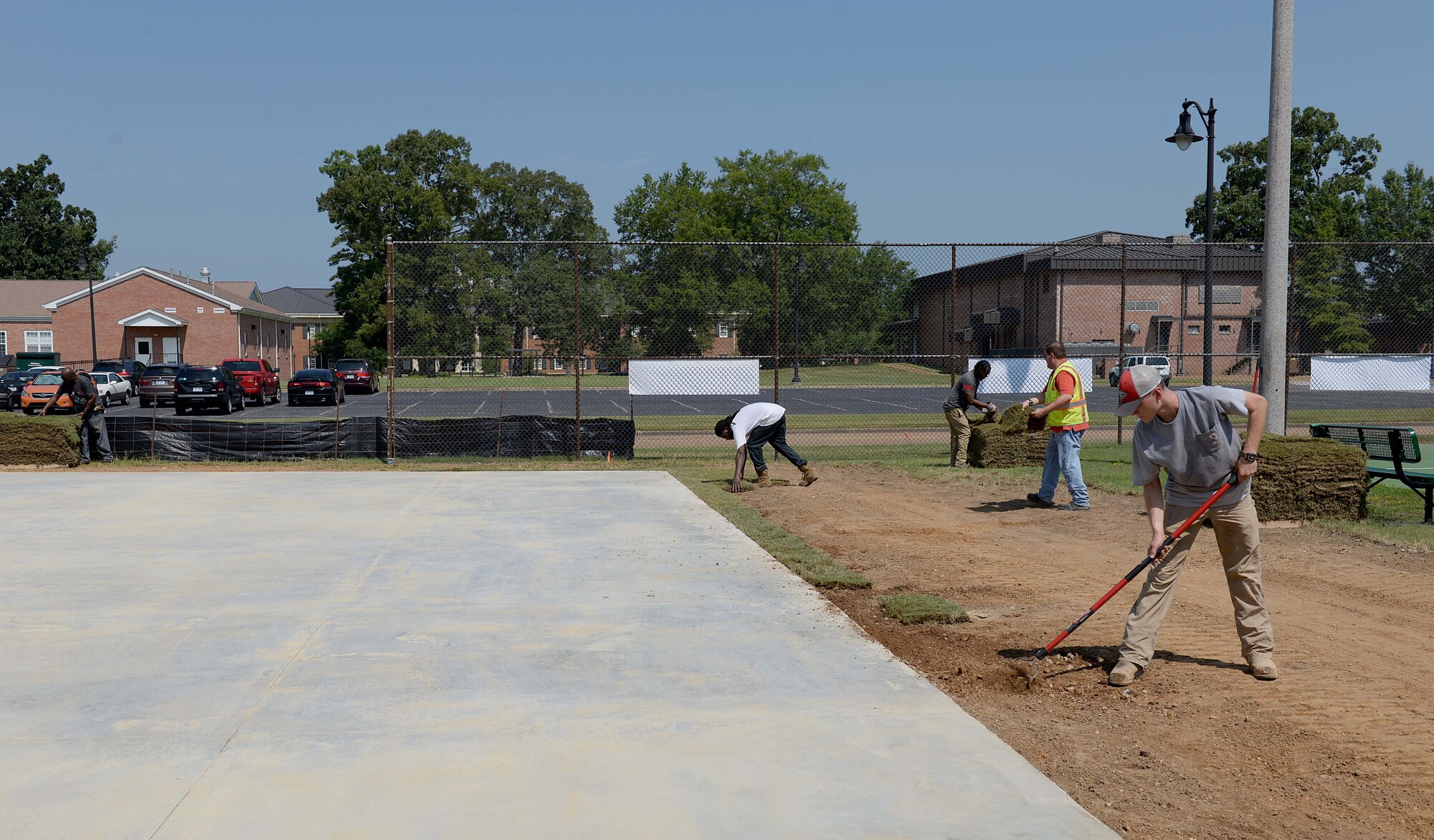 Contracted construction workers place turf around the Alpha Warrior concrete pad Aug. 13, 2018, on Columbus Air Force Base, Mississippi. Alpha Warrior designs state-of-the-art workout stations called battle rigs or battle stations, similar to the well-known “American Ninja Warrior” obstacle courses. (U.S. Air Force photo by Airman Hannah Bean)
