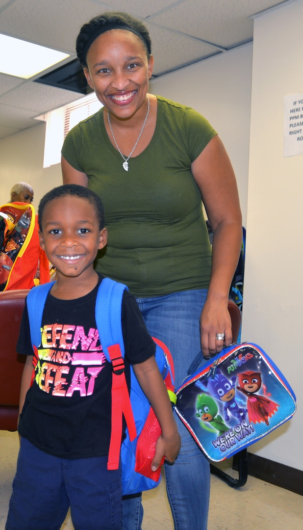 Tiffany Ladson (top) smiles with her son, Alden, after he received a backpack filled with school supplies at the Joint Base San Antonio-Fort Sam Houston Military Child Education Program-School Liaison Office Aug. 9. The program, sponsored by the JBSA Military Child Education Program-School Liaison Office, provides backpacks and school supplies for schoolchildren of military families, including active duty and wounded service members and Guard and Reserve personnel. This year, the program provided backpacks for 1,420 JBSA schoolchildren.
