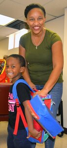 Alden Ladson, with his mother, Tiffany Ladson, shows off the new backpack he received at the Joint Base San Antonio-Fort Sam Houston Military Child Education Program-School Liaison Office Aug. 9. The backpack was donated to Alden Ladson through the Build-A-Backpack Program, which provides backpacks and school supplies for schoolchildren of military families, including active-duty and wounded service members and Guard and Reserve personnel. This year, the program provided backpacks for 1,420 JBSA schoolchildren.