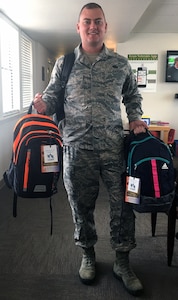 A service member picks up two backpacks for his children at the Joint Base San Antonio-Lackland Military & Family Readiness Center. The backpacks were donated through the Build-A-Backpack Program, which provides backpacks and school supplies for schoolchildren of military families, including active-duty and wounded service members and Guard and Reserve personnel. This year the program provided backpacks for 1,420 JBSA schoolchildren. The program is sponsored by the JBSA Military Education Program-School Liaison Office. The donated backpacks are provided by JBSA members.