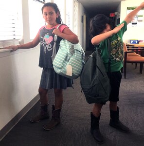 Two schoolchildren pose with the new backpacks they picked up at the Joint Base San Antonio-Lackland Military & Family Readiness Center. The backpacks were donated through the Build-A-Backpack Program, which provides backpacks and school supplies for schoolchildren of military families, including active-duty and wounded service members and Guard and Reserve personnel. This year the program provided backpacks for 1,420 JBSA schoolchildren. The program is sponsored by the JBSA Military Education Program-School Liaison Office. The donated backpacks are provided by JBSA members.