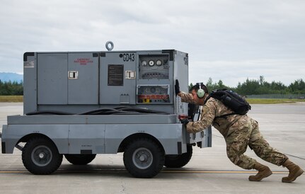 A U.S. Air Force Airman pushes ground power equipment during Red Flag-Alaska 18-3 at Joint Base Elmendorf-Richardson, Alaska, Aug. 13, 2018. RF-A is a Pacific Air Forces-directed field training exercise for U.S. and international forces flown under simulated air combat conditions. RF-A serves as an ideal platform for international engagement and the exercise has a long history of including allies and partners, ultimately enabling all involved to exchange tactics, techniques and procedures while improving interoperability.