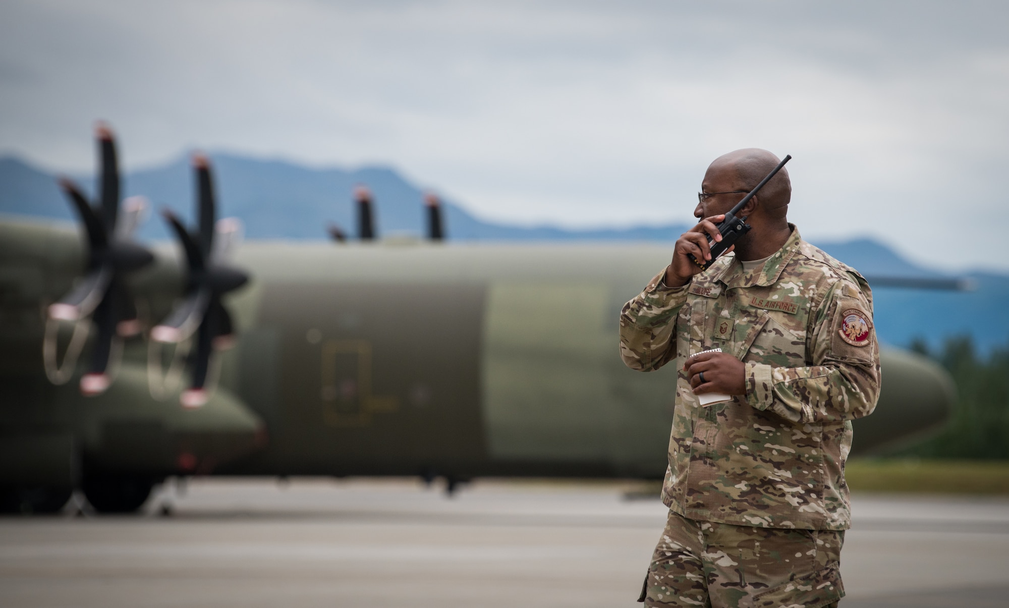 U.S. Air Force Master Sgt. Rick Moore, 353rd Special Operations Maintenance Squadron productions superintendent, speaks on a walkie-talkie at Joint Base Elmendorf-Richardson, Alaska, Aug. 13, 2018. In addition to U.S. Air Force Airmen, counterparts from Australia, Canada and the United Kingdom are also scheduled to participate, enabling the exchange of tactics, techniques and procedures while improving interoperability with fellow Airmen.