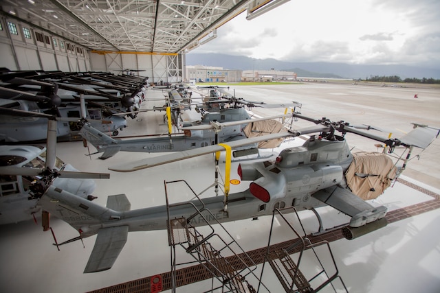 Marine helicopters are lined up in a hangar.
