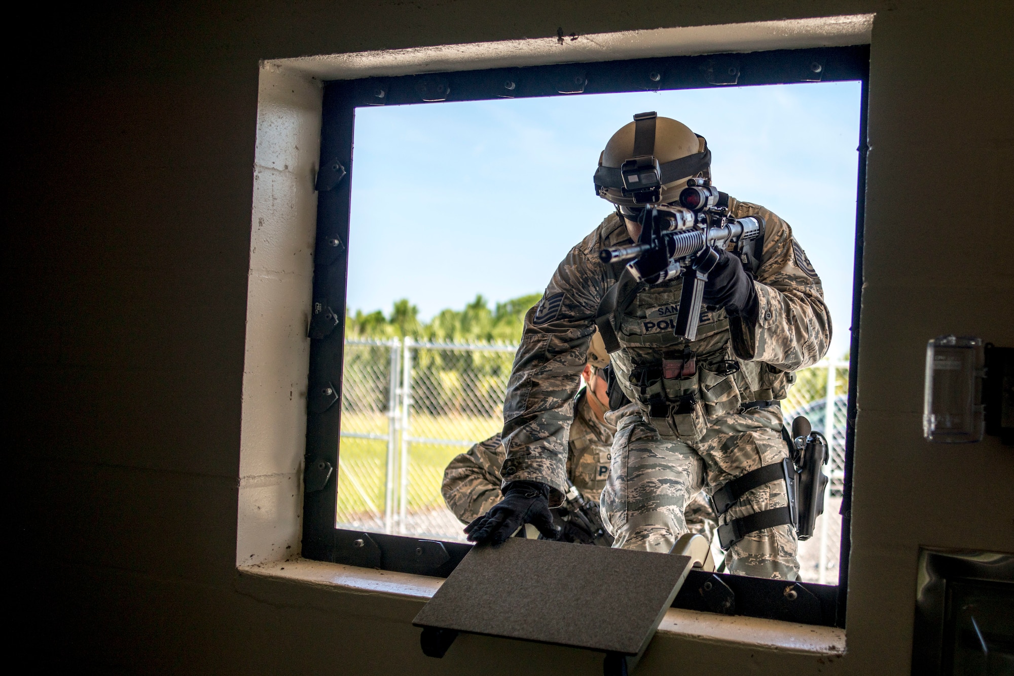 U.S. Air Force Tech. Sgt. Melvin Santos, an emergency services team leader assigned to the 6th Security Forces Squadron, climbs through a window of the simulator house at MacDill Air Force Base, Fla., Aug. 23, 2018.
