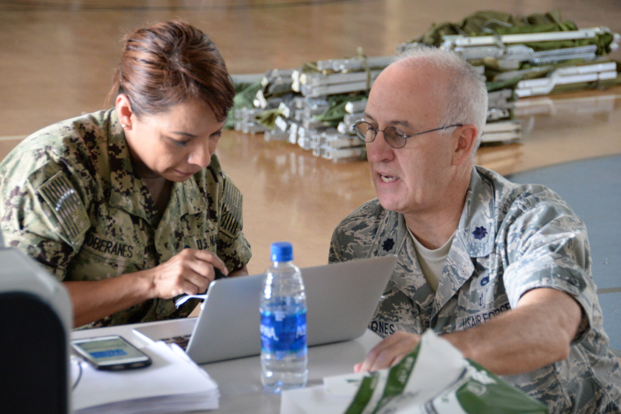 Lt. Col. James Jones speaks with U.S. Navy Lt. Cmdr. Maricela Soberanes.