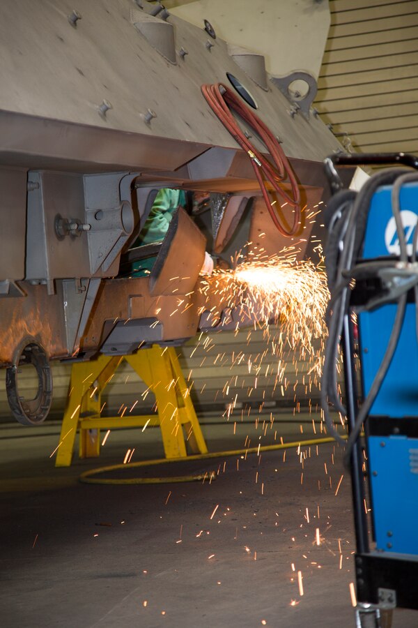 Sithan Lay, welder, cuts a wheel well on a light armored vehicle 25, at Production Plant Barstow, Marine Depot Maintenance Command, on the Yermo Annex aboard Marine Corps Logistics Base Barstow, Calif., Aug. 16. The defective armor plate was removed and replaced with a newly fabricated plate.