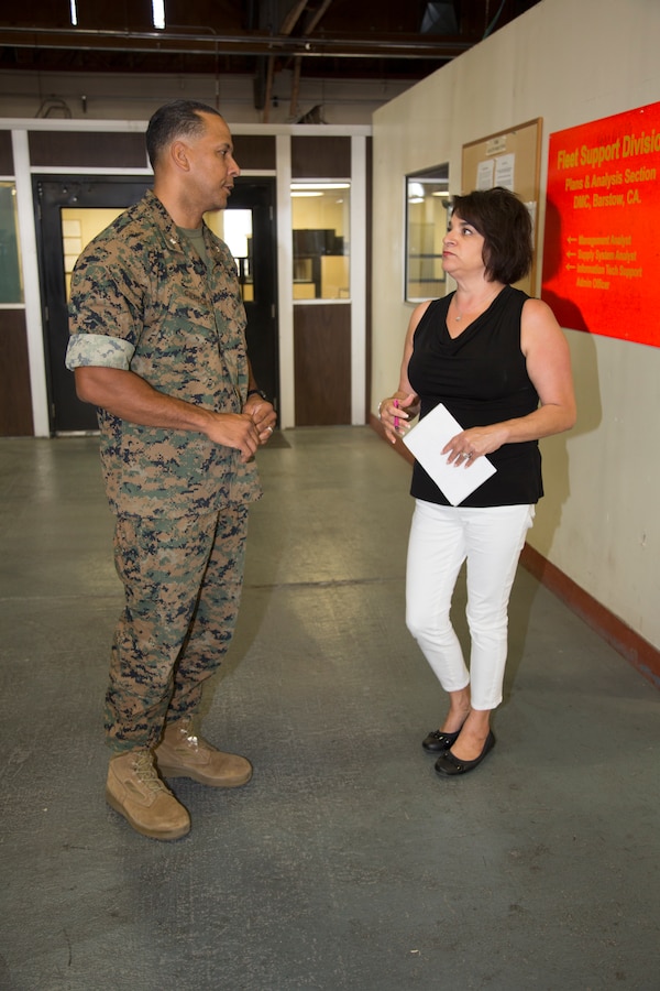 Lieutenant Colonel Tarrell Giersch talks with Samantha Atkinson, management analyst, at Fleet Support Division aboard the Yermo Annex of Marine Corps Logistics Base Barstow, Calif, Aug. 17. Giersch is a mustang, or an enlisted Marine who was chosen to attend Officer Candidate School. Giersch is the new director of FSD, taking over the slot Aug. 1