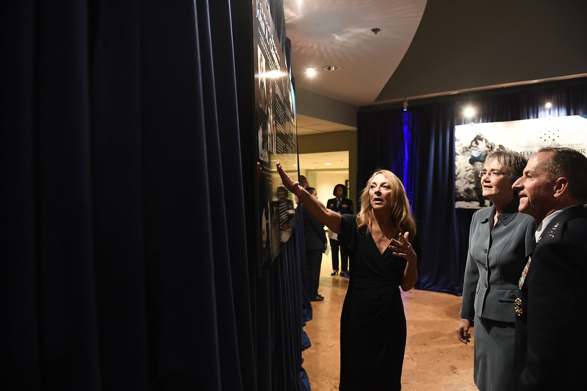 Secretary of the Air Force Heather Wilson, Air Force Chief of Staff Gen. David L. Goldfein and Valerie Nessel, widow of Tech. Sgt. John Chapman, view artwork prior to Chapman's Pentagon Hall of Heroes induction ceremony at the Pentagon, in Arlington, Va., Aug. 23, 2018. Chapman was posthumously awarded the Medal of Honor for actions on Takur Ghar Mountain in Afghanistan March 4, 2002. An elite special operations team was ambushed by the enemy and came under heavy fire from multiple directions. Chapman immediately charged an enemy bunker through thigh-deep snow and killed all enemy occupants. Courageously moving from cover to assault a second machine gun bunker, he was injured by enemy fire. Despite severe wounds, he fought relentlessly, sustaining a violent engagement with multiple enemy personnel before making the ultimate sacrifice. With his last actions he saved the lives of his teammates. (U.S. Air Force photo by Staff Sgt. Rusty Frank)