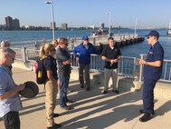 A member from the U.S. Coast Guard briefs Joint Task Force Civil Support members and other participants of the 2018 DoD Support of Civil Authorities (DSCA)/Chemical, Biological, Radiological and Nuclear (CBRN) Dense Urban Terrain Training Tactical Exercise Without Troops exercise Aug. 21-23 in Detroit, Mich. The Detroit River serves as an international border, as well as a means of transportation and commerce and would be significantly affected during a disaster. The task force members were among the 150 participants from more than 50 organizations of the interagency, to include local, state, federal and international partners. They gathered to increase their readiness for the CBRN mission with a focus on operating in a dense urban environment. Detroit is an inland seaport and handles traffic from all over the world by way of various connecting waterways and so afforded the training attendees with the opportunity to consider the challenges of responding to a DSCA event by water. The training was held by the 46th Military Police Command, Michigan Army National Guard, Command and Control CBRN Response Element – Bravo and also included training within the city landscape. (Official DoD photo by Air Force Lt. Col. Karen Roganov/released)