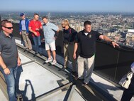 Members of Joint Task Force Civil Support discuss the challenges of operating within an urban environment from a rooftop of a skyscraper during the 2018 DoD Support of Civil Authorities (DSCA)/Chemical, Biological, Radiological and Nuclear (CBRN) Dense Urban Terrain Training Tactical Exercise Without Troops exercise held August 21-23 in Detroit Michigan. The task force members were among some of the 150 participants from more than 50 organizations of the interagency, to include local, state, federal and international partners. The attendees studied the layout of the city and discussed the challenges of conducting urban search and rescue and other DSCA rescue efforts in a city such as Detroit, which ranks third in the state for population density. The training was held by the 46th Military Police Command, Michigan Army National Guard, Command and Control CBRN Response Element – Bravo and included other key training stops within the city landscape. (Official DoD photo by Air Force Lt. Col. Karen Roganov /released)