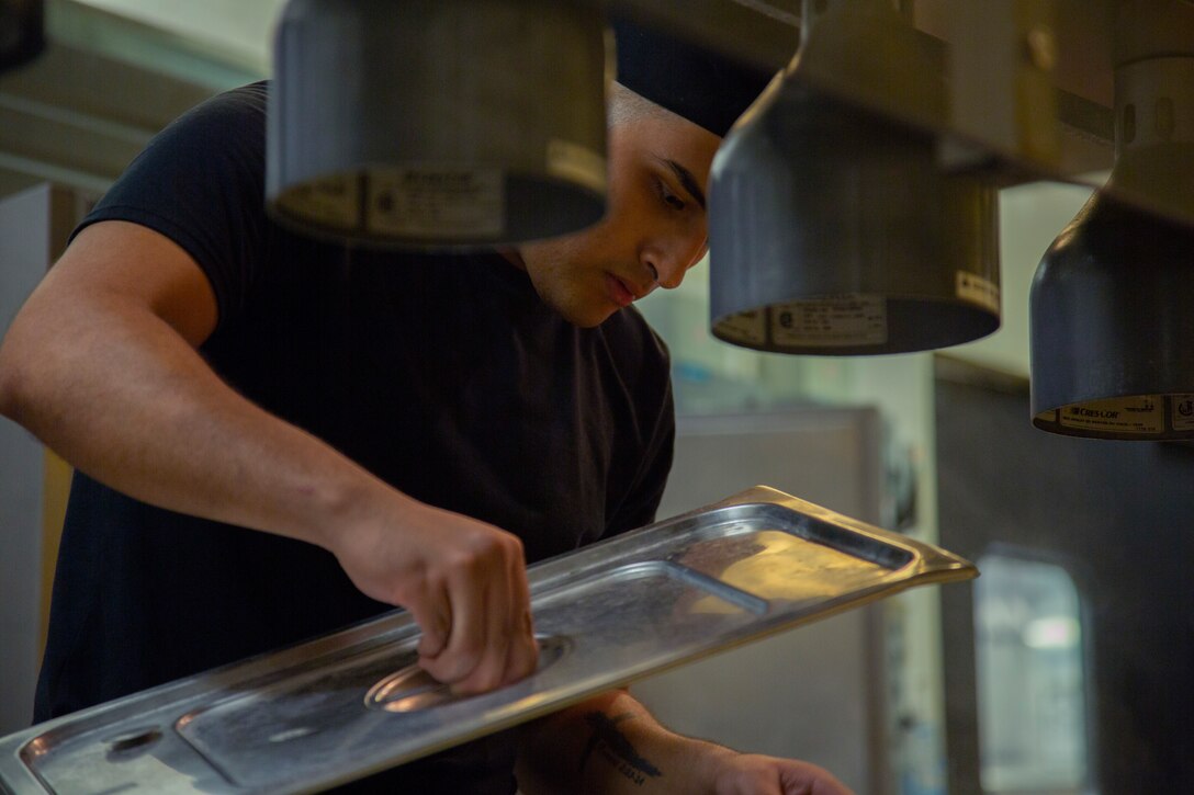 Pfc. Havier Contreras prepares the food counter in preparation for the afternoon meal at the Camp Kinser Mess Hall, Okinawa, Japan, Aug. 15, 2018. Food service specialists provide food and cafeteria facilities for fleet Marine forces in both field and garrison environments. Contreras, a food service specialist with Food Service Company, Headquarters Regiment, 3rd Marine Logistics Group, is a native of San Antonio, Texas. (U.S. Marine Corps photo by Pfc. Mark Fike)
