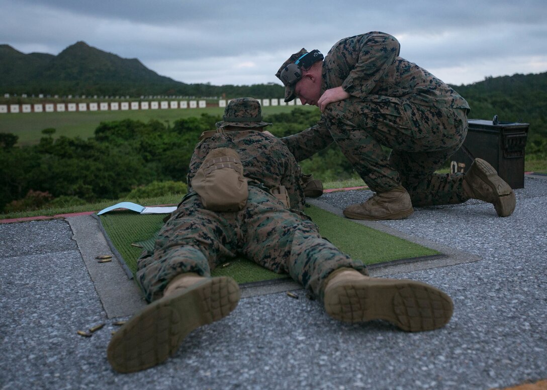 Lance Cpl. Timothy Larrigan, a range coach from Headquarters Battalion, 3rd Marine Division, gives advice to a fellow Marine during annual rifle range qualification on Camp Hansen, Okinawa, Japan, August 20, 2018. Marines qualify annually with the M16A4 service rifle to maintain combat effectiveness. Larrigan is a native of Fenton, Missouri. (U.S. Marine Corps photo by. Lance Cpl Christine Phelps)