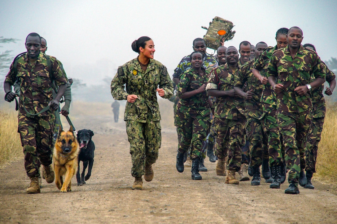 A sailor runs with a group of Kenyan service members