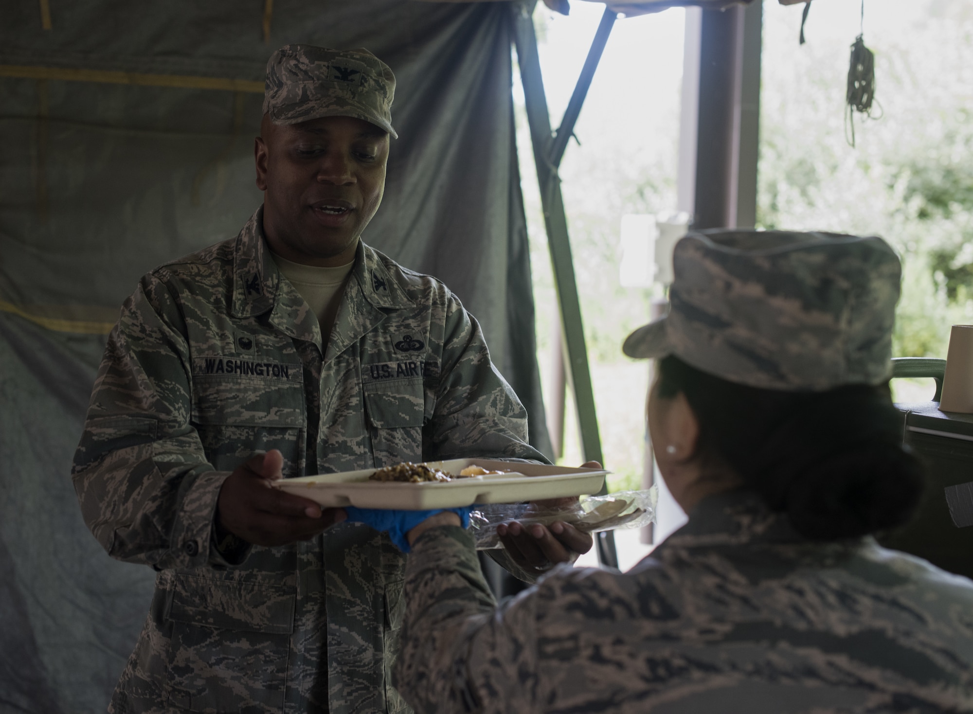 U.S. Air Force Col. Dalian Washington, 87th Mission Support Group commander, receives a portion of unit group rations during a Single Pallet Expeditionary Kitchen training exercise on Joint Base McGuire-Dix-Lakehurst, N.J., Aug. 17, 2018. The Airmen setup the SPEK to simulate a deployed environment and learn what to expect and how to handle situations if they get deployed.