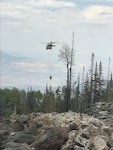 UH-60 Black Hawk helicopters, equipped with aerial water buckets, from the Chief Warrant Officer 5 David R. Carter Army Aviation Support Facility based at Buckley Air Force Base, Aurora, Colorado, drop water on the Cache Creek Fire, in Garfield County, Colorado, to support fire suppression efforts Aug. 17, 2018.