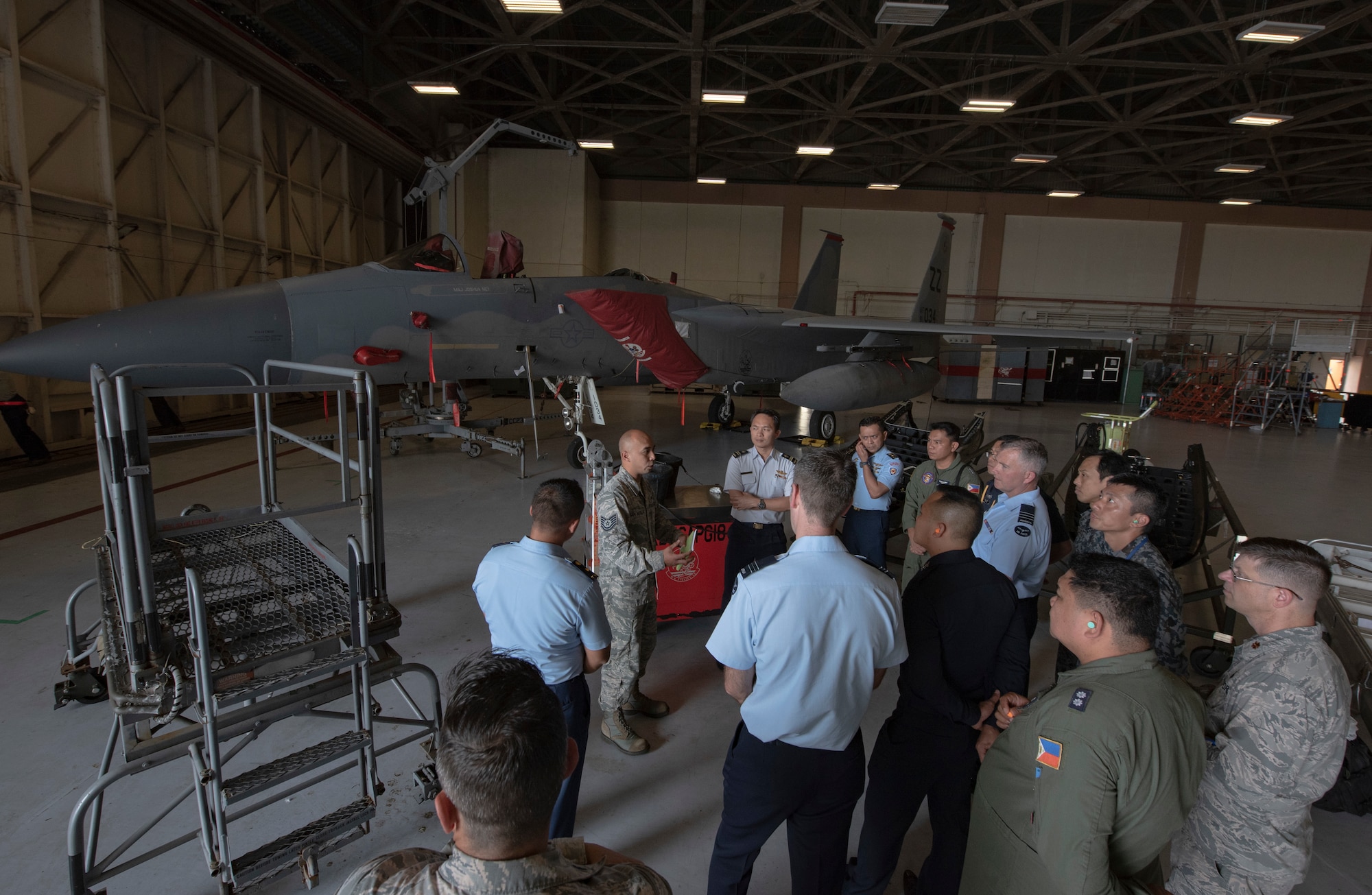 U.S. Air Force Tech. Sgt. Gene San Nicolas, 18th Equipment Maintenance Squadron aircraft inspection NCOIC, briefs officers of allied and partner nations about aircraft ground equipment during the 2018 Fighter Logistics and Safety Symposium Aug. 21, 2018, at Kadena Air Base, Japan. During the symposium, air force officers from Australia, Indonesia, Japan, the Philippines, Singapore, Thailand and the U.S. exchanged solutions to common challenges faced in the fighter community. (U.S. Air Force photo by Staff Sgt. Micaiah Anthony)