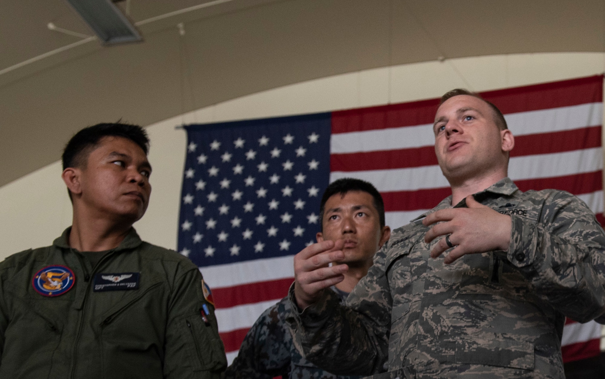 U.S. Air Force Master Sgt. Benjamin Bouvy, 18th Maintenance Group loading standardization crew chief, briefs officers of allied and partner nations about the logistics of loading munitions to an F-15 Eagle during the 2018 Fighter Logistics and Safety Symposium Aug. 21, 2018, at Kadena Air Base, Japan. The symposium enabled air force officers from Australia, Indonesia, Japan, the Philippines, Singapore and Thailand to visit fighter support units assigned to the 18th Wing and interact with Airmen who support the fighter mission. (U.S. Air Force photo by Staff Sgt. Micaiah Anthony)