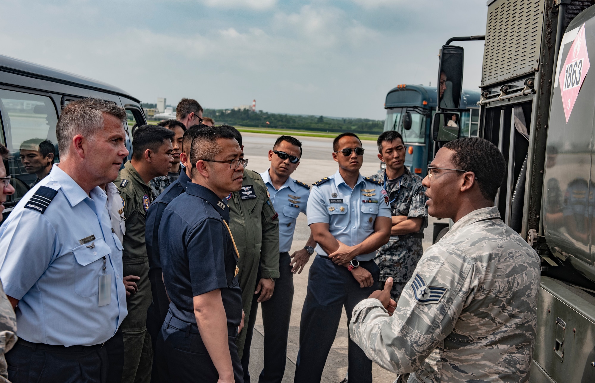 U.S. Air Force Staff Sgt. Jerald Hickmon, 18th Logistics Readiness Squadron Fuels Service Center NCOIC, briefs officers of allied and partner nations about aircraft fueling operations during the 2018 Fighter Logistics and Safety Symposium Aug. 21, 2018, at Kadena Air Base, Japan. The symposium enabled air force officers from Australia, Indonesia, Japan, the Philippines, Singapore and Thailand to visit fighter support units assigned to the 18th Wing and interact with Airmen who support the fighter mission. (U.S. Air Force photo by Staff Sgt. Micaiah Anthony)