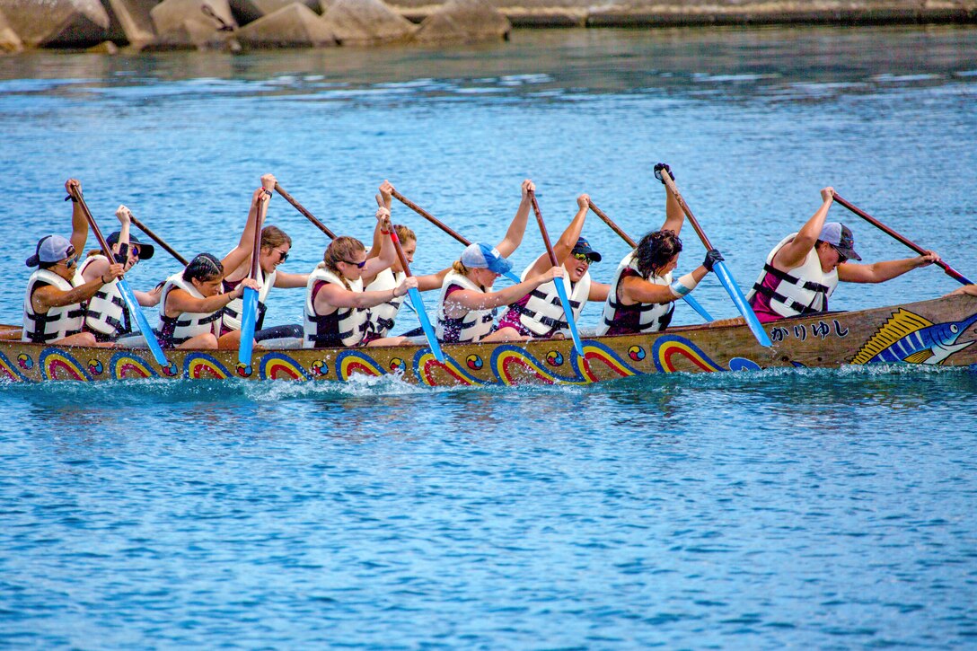 A dragon boat team rows through the water.