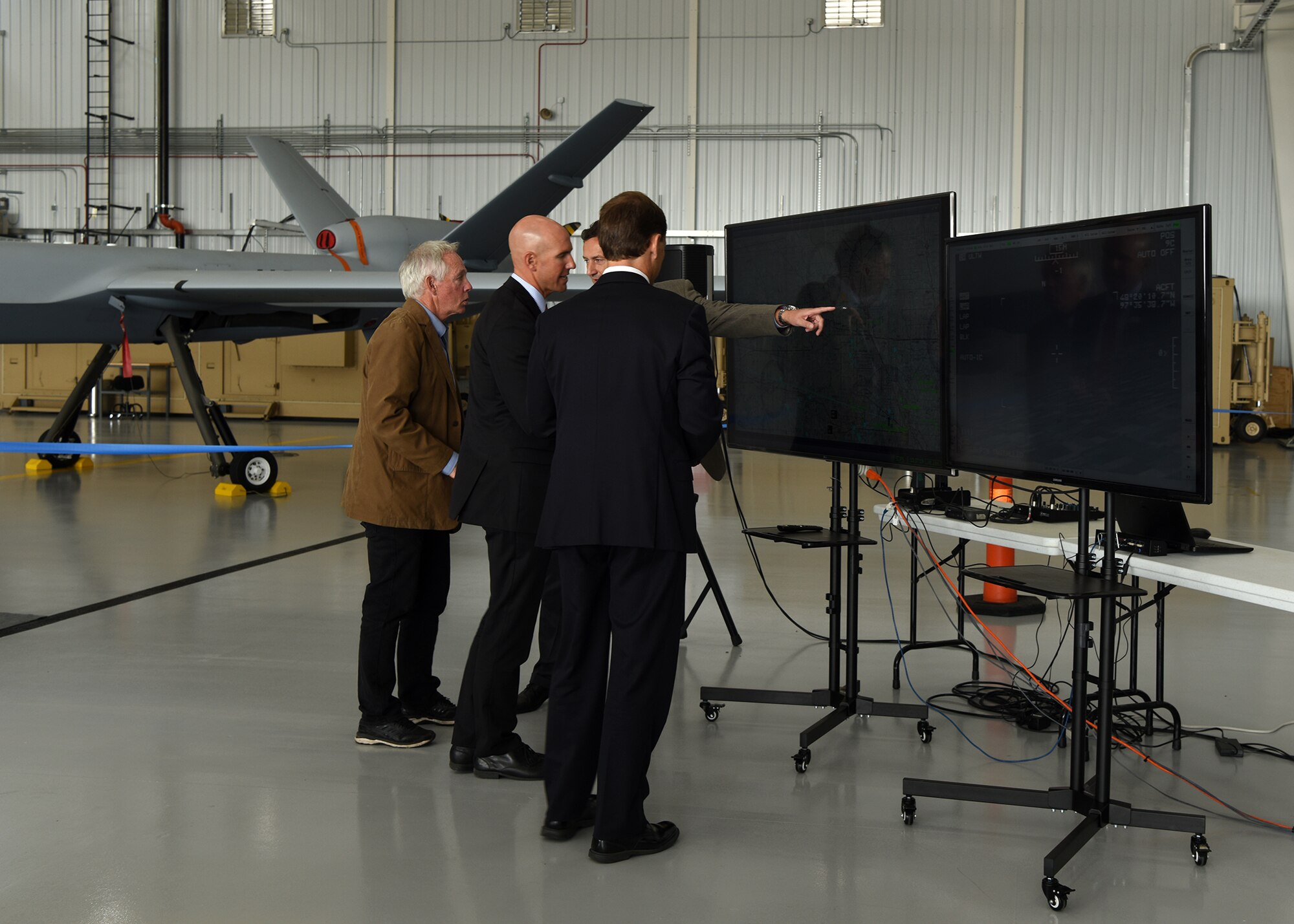 Attendees at the first civil beyond visual line of sight public event at Grand Sky Development Company watch the live MQ-9 camera feed during first ever flight operation of an unmanned aircraft flying without a chase-plane Aug. 20, 2018 at Grand Sky on Grand Forks Air Force Base, North Dakota. BVLOS flight testing is a crucial step toward fully integrating commercial large UAS and small drone operations into pubic airspace, and Grand Sky is at the center of activity. (U.S. Air Force photo by Senior Airman Cierra Presentado)