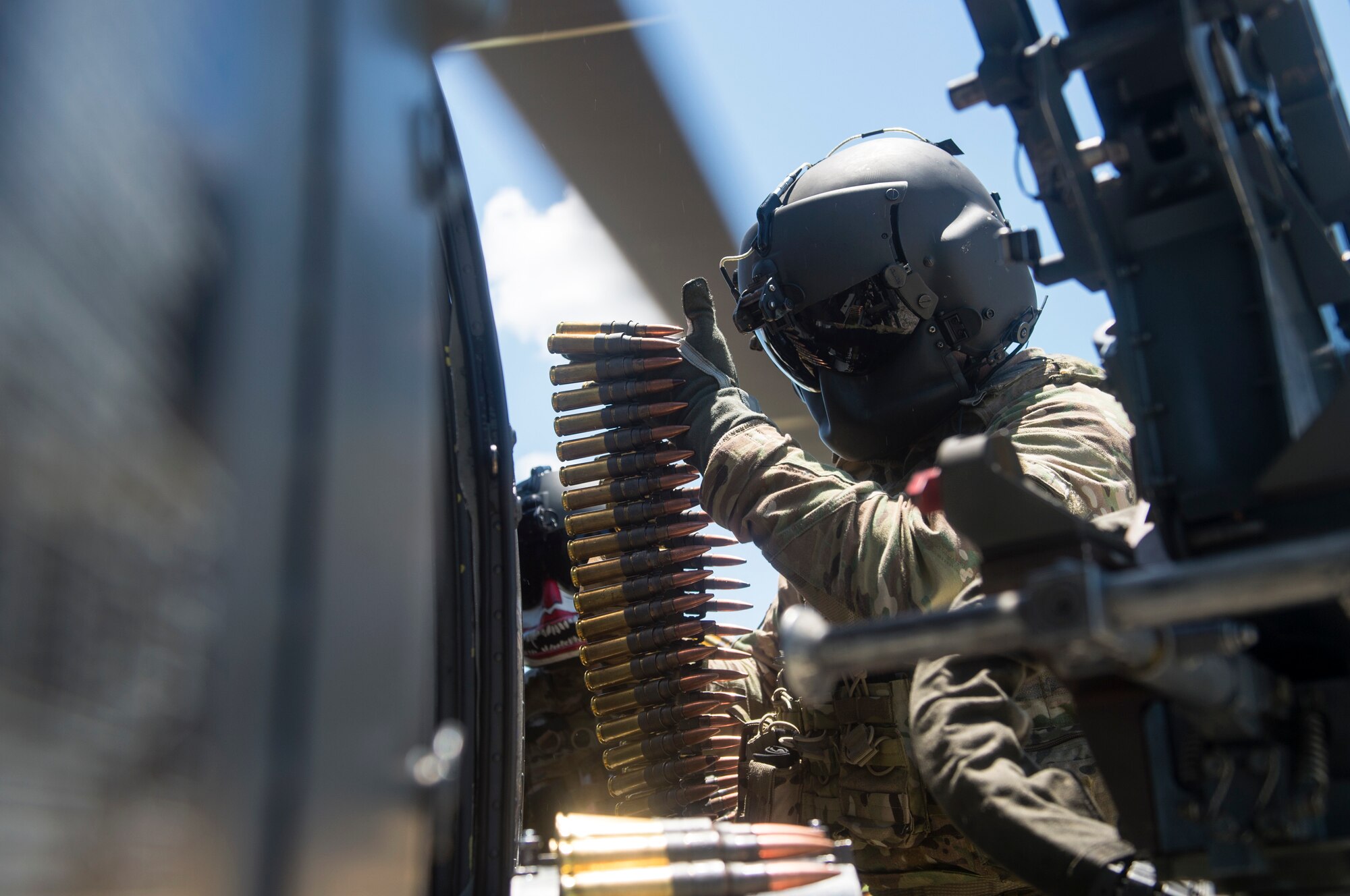 Special missions aviators from the 41st Rescue Squadron (RQS) load ammunition into an M2 machine gun mounted to an HH-60G Pave Hawk, Aug. 17, 2018, at Patrick Air Force Base, Fla. Airmen from the 41st RQS and 41st Helicopter Maintenance Unit traveled to Patrick AFB to participate in a spin-up exercise. During the exercise, Airmen faced scenarios and situations they may encounter downrange. (U.S. Air Force photo by Senior Airman Janiqua P. Robinson)