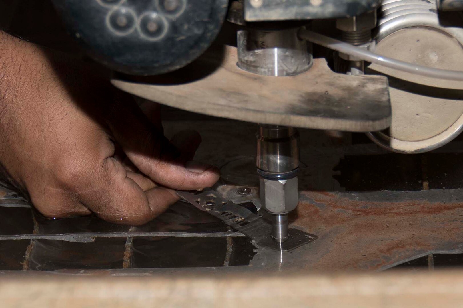 U.S. Air Force Staff Sgt. Terence Lewis, a Metals Technology Specialist assigned to the 307th Maintenance Squadron, demonstrates the capability of an OMAX 55100 JetMachining Center at Barksdale Air Force Base, Louisiana, Aug. 4, 2018.  The water jet is one of several precision machines that allow Airmen to take a repair or fabrication project from start to finish with regard to design and assembly. (U.S. Air Force photo by Staff Sgt. Callie Ware)