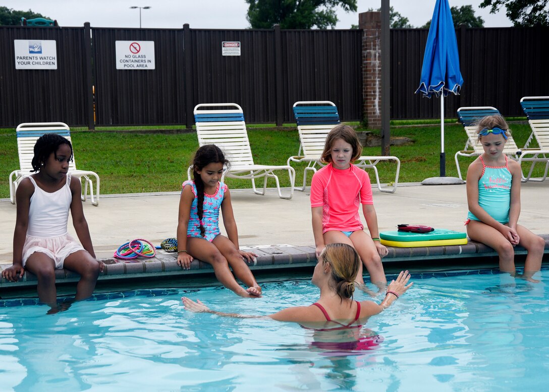 Eliza Shee, water safety instructor, teaches camp participants how to swim at Joint Base Andrews, Md., Aug. 21, 2018. During the four-day camp, kids learned a variety of skills from first responders, water safety instructors and camp counselors in and out of the pool. (U.S. Air Force photo by Senior Airman Abby L. Richardson)