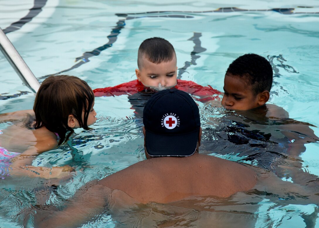 Bobby Broome, Joint Base Andrews pool manager and aquatics director, teaches kids how to submerge their faces during a water safety camp at Joint Base Andrews, Md., Aug. 21, 2018. Camp participants learned the basics of swimming as well as water safety and life-saving techniques. (U.S. Air Force photo by Senior Airman Abby L. Richardson)