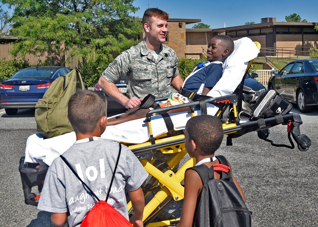 Staff Sgt. Troy Stallard, 11th Medical Operations Squadron paramedic, demonstrates how to use a stretcher during the third annual water safety camp at Joint Base Andrews, Md., Aug. 23, 2018. Camp participants met with representatives from security forces, the fire department, emergency services and the Red Cross to teach them about what first responders do in an emergency. (U.S. Air Force photo by Senior Airman Abby L. Richardson)