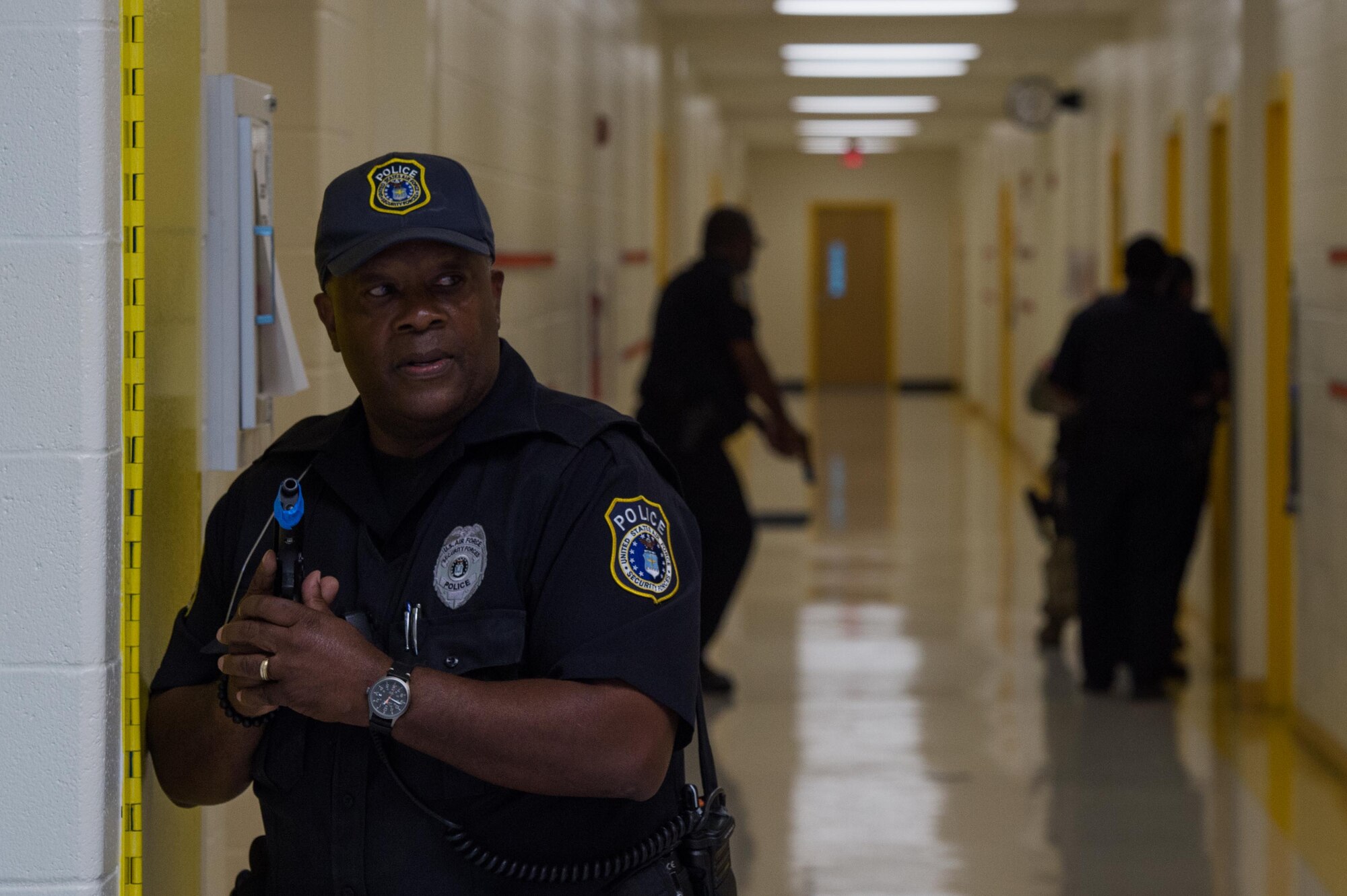 A 733rd Security Forces Squadron officer keeps watch as other officers clear rooms during a school violence exercise at Joint Base Langley-Eustis, Virginia, Aug. 23, 2018.