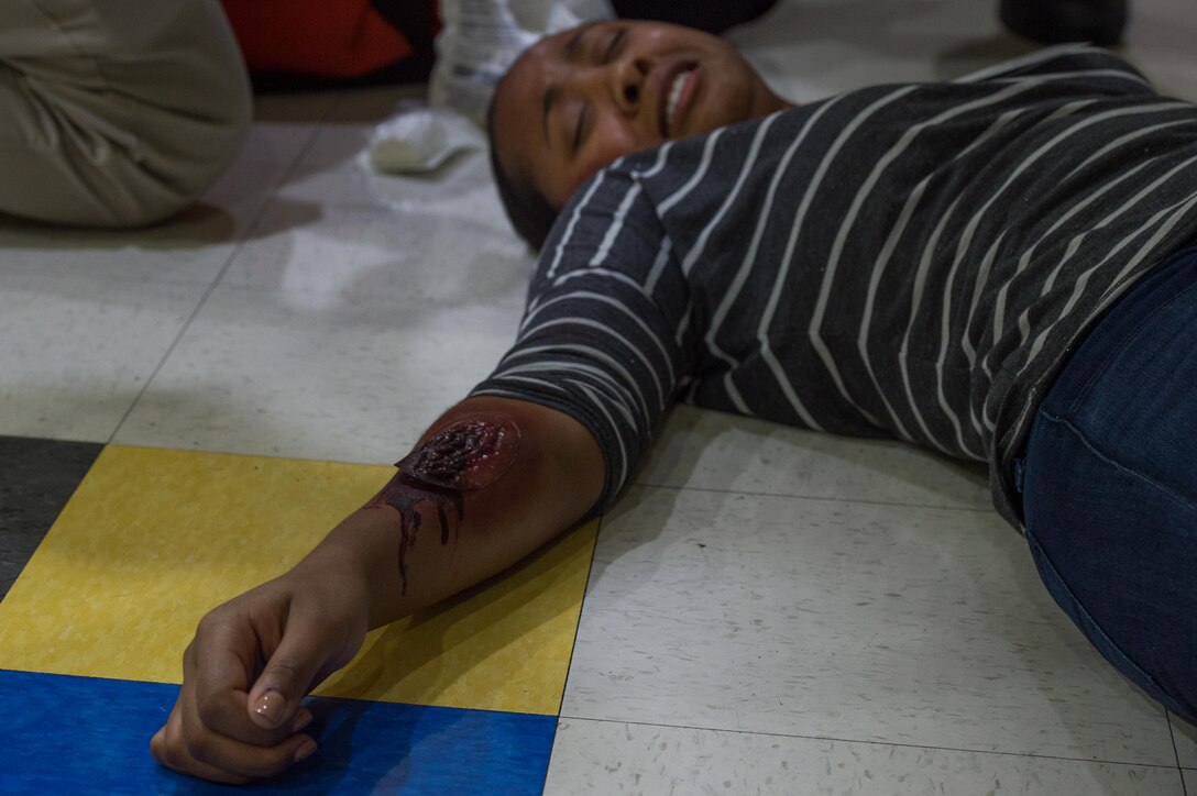 A role player acts as an injured victim during a school violence exercise at Joint Base Langley-Eustis, Virginia, Aug. 23, 2018