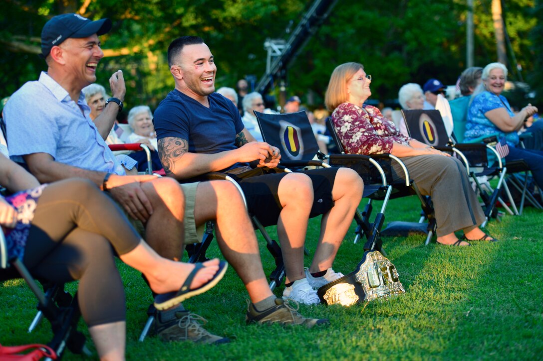 U.S. Army Gen. Stephen J. Townsend, U.S. Army Training and Doctrine Command commanding general, left, and Colby Covington, UFC welterweight champion, right, share a laugh during the TRADOC Band’s 86th season finale of Music Under the Stars at Joint Base Langley-Eustis, Virginia, Aug. 23, 2018.