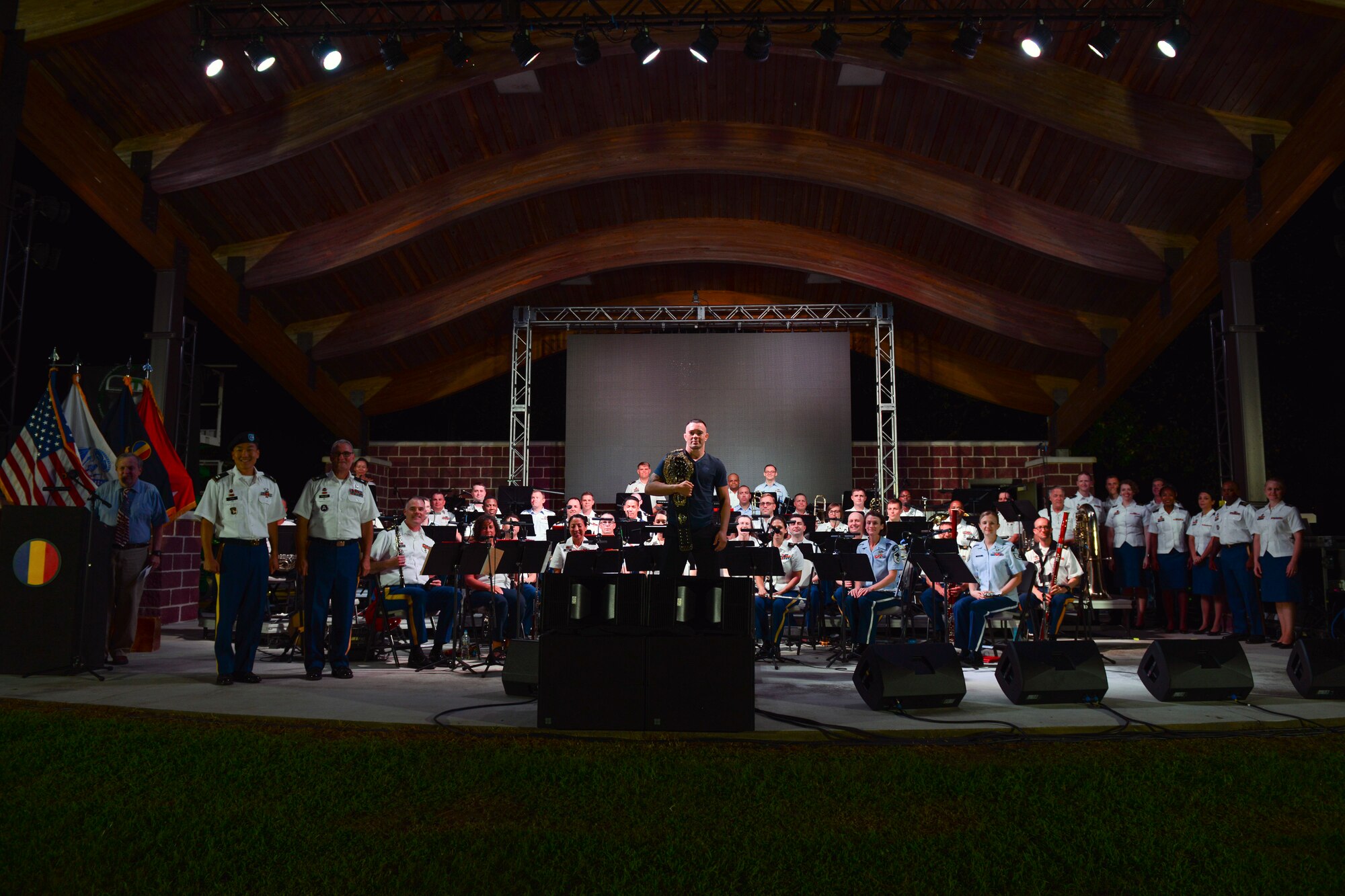 Colby Covington, UFC welterweight champion, center, poses with the U.S. Army Training and Doctrine Command Band during the Music Under the Stars 86th season finale concert at Joint Base Langley-Eustis, Virginia, Aug. 23, 2018.