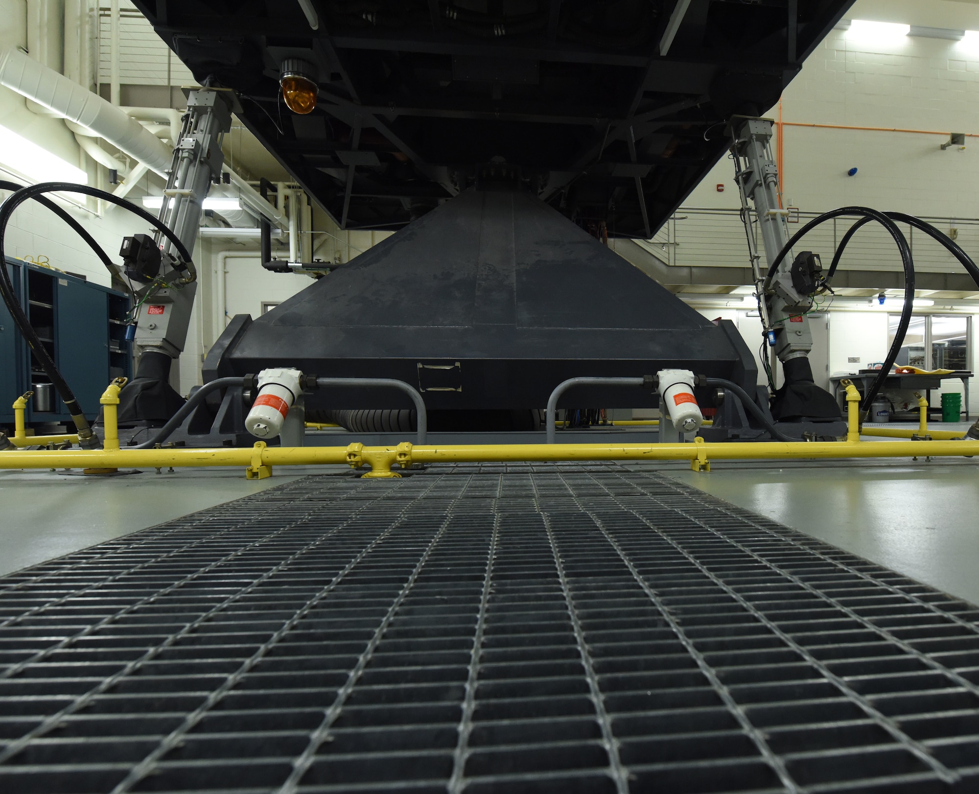 Hydraulic arms are used to control the movement of a B-1 simulator at Ellsworth Air Force Base, S.D., Aug. 21, 2018. The WSTs sits on hydraulic legs, which allow them to move forwards and backwards during training to make it as realistic as possible so aircrew members can more effective in real-world situations. (U.S. Air Force photo by Airman 1st Class Thomas Karol)