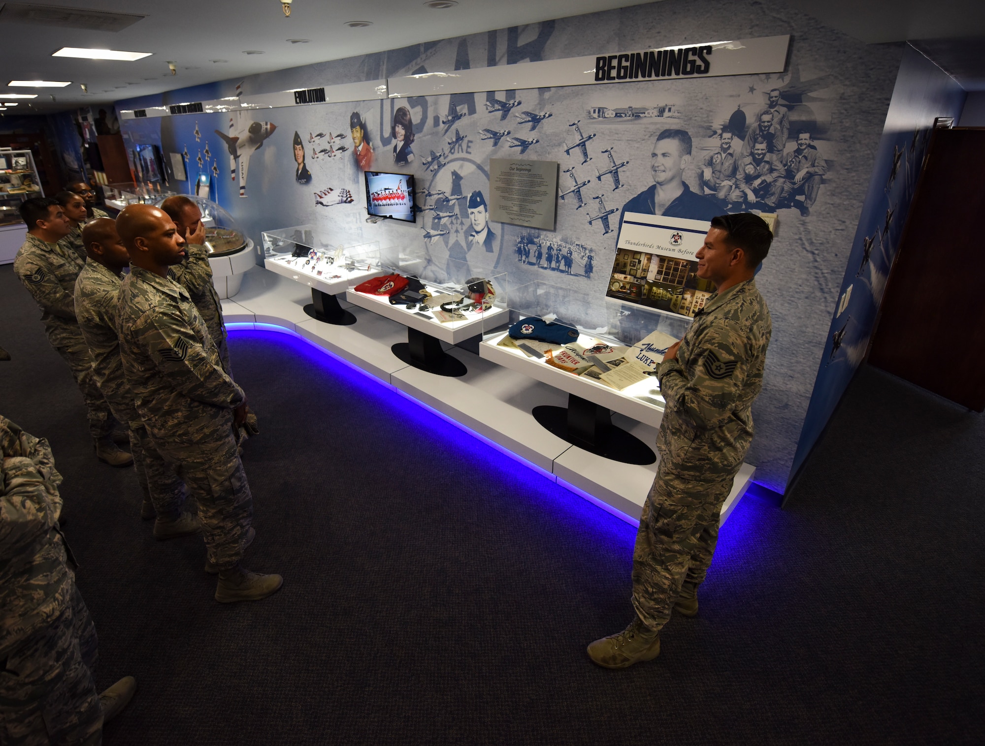Tech. Sgt. Daniel Wolfrum, Thunderbirds plans and scheduling NCO in charge, conducts a tour of the Thunderbird museum at Nellis Air Force Base, Nevada, Aug. 16, 2018. The museum displays Thunderbirds heritage, memorabilia and current team members. (U.S. Air Force photo by Airman 1st Class Andrew D. Sarver)