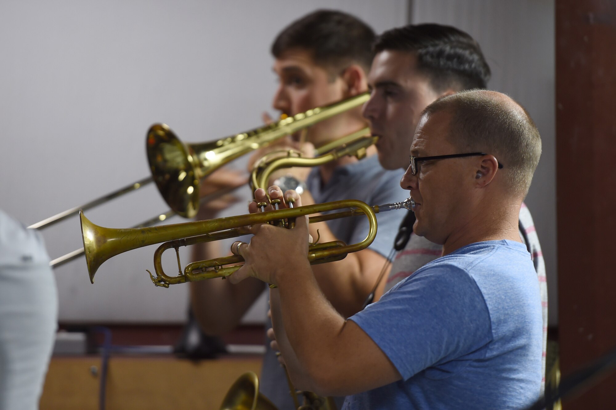 Three Airmen play instruments on a small stage