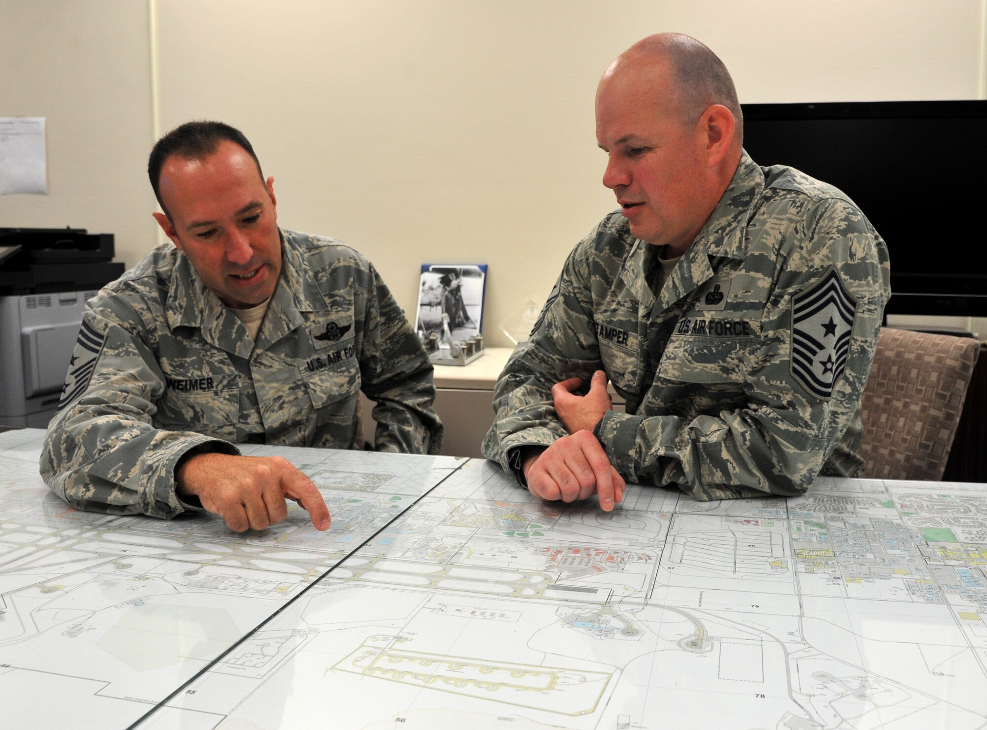 Command Chief Master Sgts. Daniel Weimer, 58th Special Operations Wing (left), and Robert Stamper, 377th Air Base Wing (right), discuss cooperation between their respective wings here Aug. 23. (U.S. Air Force photo by Jim Fisher)