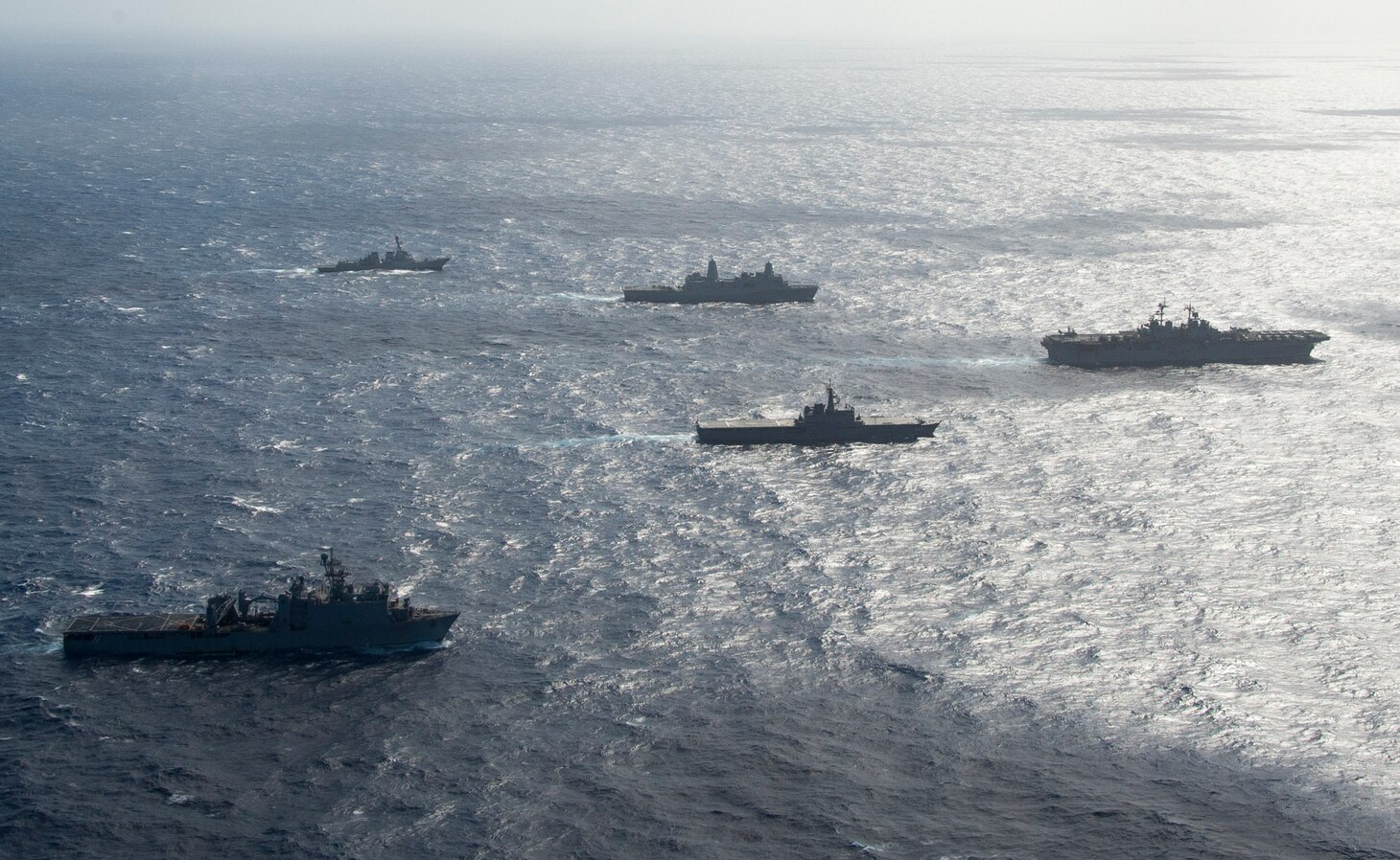 The amphibious assault ship USS Wasp (LHD 1), along with the transport dock ship USS Green Bay (LPD 20), dock landing ship USS Ashland (LSD 48), and Arleigh Burke class guided missile destroyer USS Shoup (DDG 86), sail alongside the Japan Maritime Self Defense Force (JMSDF) amphibious transport dock ship JS Osumi (LST 4001) during a Passing Exercise (PASSEX) in the Philippine Sea Aug. 26, 2018. PASSEX enabled the Wasp ARG and the JMSDF a chance to practice communications and maneuvering procedures, and enhance combined amphibious capabilities. The Wasp ARG is currently operating in the region to enhance interoperability with partners and serve as a ready-response force for any type of contingency.