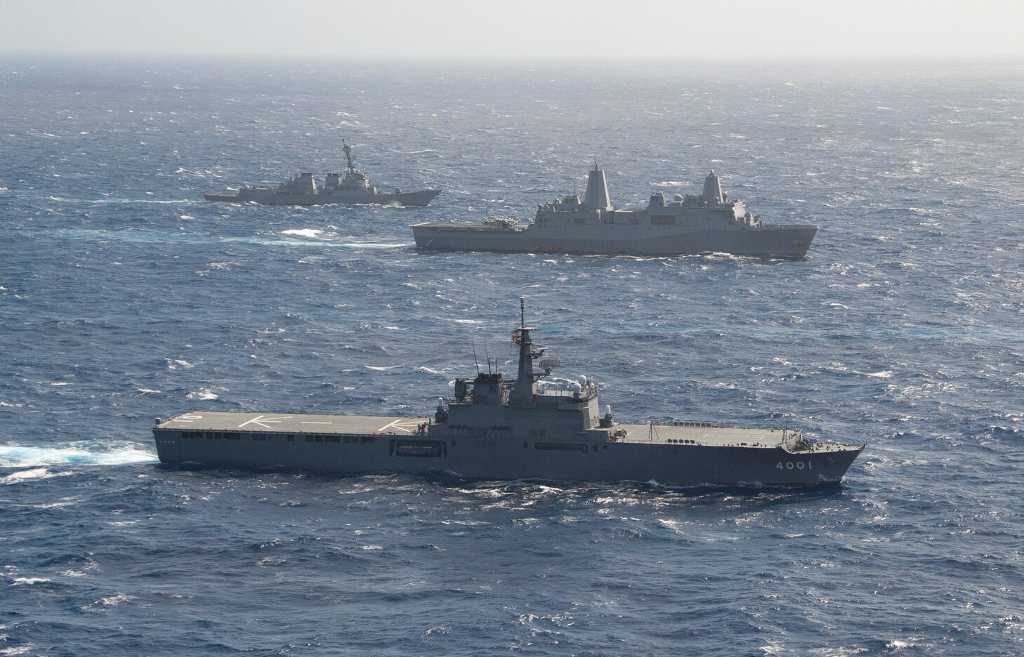 The Japan Maritime Self Defense Force (JMSDF) amphibious transport dock ship JS Osumi (LST 4001),  transport dock ship USS Green Bay (LPD 20), and Arleigh Burke class guided missile destroyer USS Shoup (DDG 86) sail alongside during a Passing Exercise (PASSEX) in the Philippine Sea Aug. 26, 2018. PASSEX enabled the Wasp ARG and the JMSDF a chance to practice communications and maneuvering procedures. The Wasp ARG is currently operating in the region to enhance interoperability with partners and serve as a ready-response force for any type of contingency.