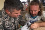 An Air Force nurse removes fishing line from an injured bird.