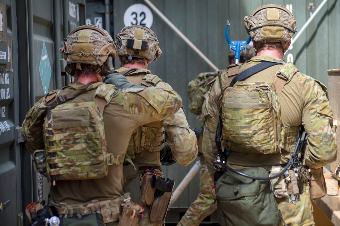 Australian soldiers move in a stacked formation while conducting visit, board, search and seizure operations.