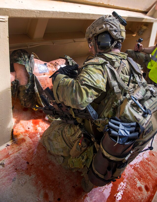An Australian soldier provides medical care to simulated casualty while conducting visit, board, search and seizure operations.