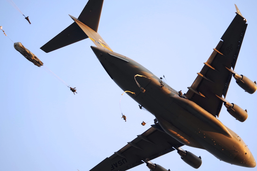 Soldiers jump from an Air Force C-17 Globemaster aircraft while conducting a static-line airborne operation.