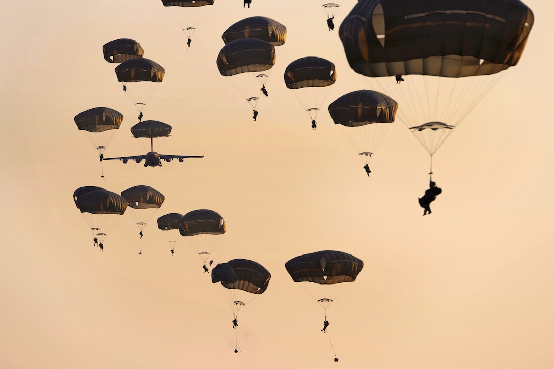 Soldiers descend after jumping from an Air Force C-17 Globemaster aircraft.