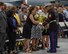 U. S. Marine Sgt. Joel Gonzalez presents a bouquet of yellow roses to Mrs. Maureen Lyons on behalf of the men and women of U.S. Transportation Command.