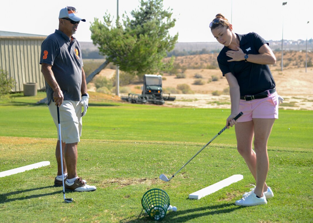 Air Force retiree Henry Ponce receives golfing tips from professional golfer Molly Aronsson during a golf clinic at Muroc Lake Golf Course on Edwards Air Force Base, Aug. 24. (U.S Air Force photo by Giancarlo Casem)