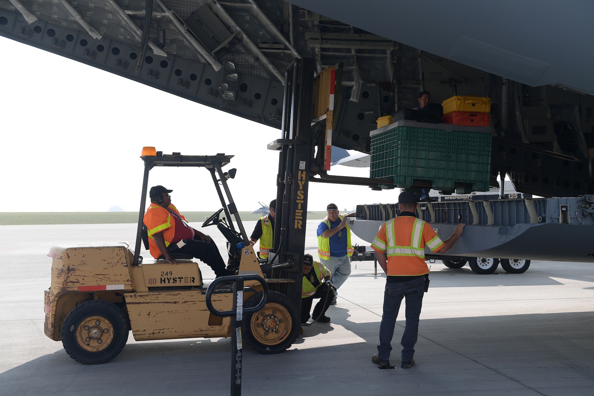 A team of government and civilian contractors load the remaining support cargo after securing the very first GPS III satellite onto a C-17 Globemaster III at Buckley Air Force Base, Colorado, Aug. 20, 2018.