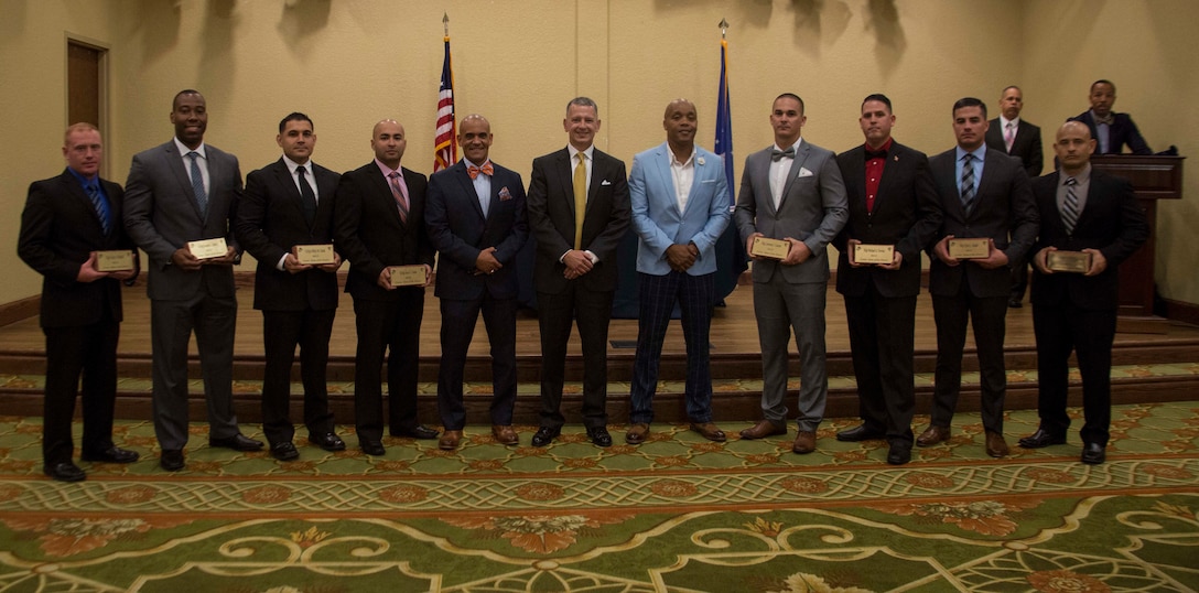 Col. William C. Gray, 6th Marine Corps District commanding officer, Sgt. Maj. Rafael Rodriguez, the Eastern Recruiting Region and Marine Corps Recruit Depot Parris Island sergeant major, and Sgt. Maj. Cortez L. Brown, 6th Marine Corps District sergeant major, present gifts to 6th MCD’s newest 8412 Marines at a professional dinner during the 8412 Symposium at Keesler Air Force Base, Mississippi, Aug. 23, 2018. The symposium brought all 6th MCD career recruiters, sergeants major and commanding officers together to provide information, develop updated recruiting products, and conduct sustainment training for the professional development of the recruiting force. (U.S. Marine Corps photo by Cpl. Jorge A. Rosales)